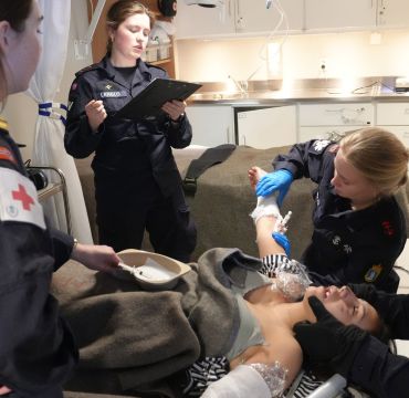 Det gjennomføres daglige øvelser gjennom hele toktet. Her er det saniteten som har fått inn en skadd person etter en brann- og redningsøvelse, med en menig som frivillig markør. Sanitetspersonellet får trent på det de har lært, og vernepliktig lege følger med. 
