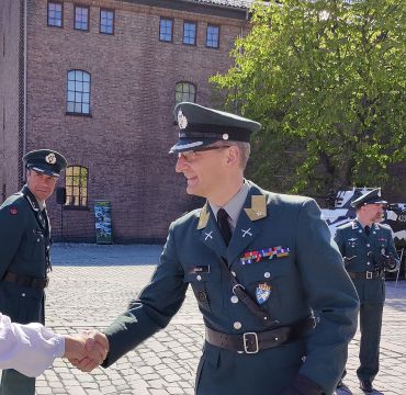 Gro Jære og Øyvind Kvalvik gir hverandre et håndtrykk på Akershus Festning  i forbindelse med 8. mai-markeringen.